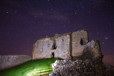 Low angle view of old building against sky at night