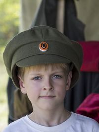 Close-up portrait of boy wearing uniform hat at event