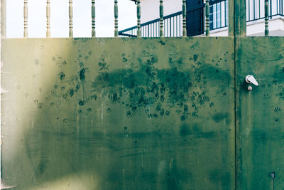 Reflection of metal fence on wall