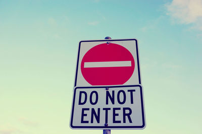 Low angle view of do not enter sign against sky
