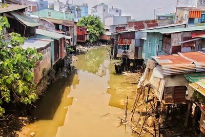 Canal amidst houses against buildings in city