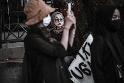 Midsection of woman with arms mask