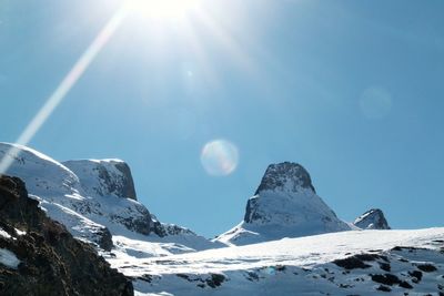 Scenic view of snowcapped mountains against sky on sunny day