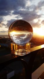 Close-up of beer glass on table against sky during sunset