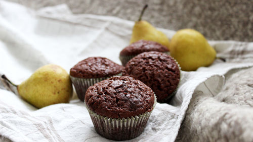 Close-up of cupcakes and pears on napkin