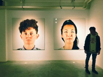 Portrait of young man standing against wall