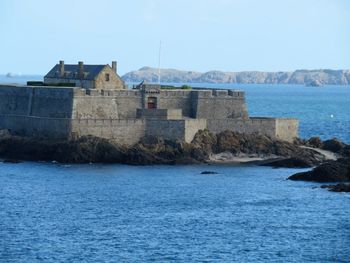 Fortress by sea against clear sky