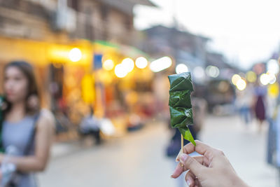 Woman holding ice cream cone on street