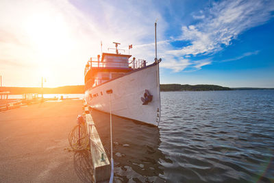 Fishing boat on sea against sky at sunset