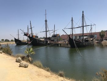 Sailboats moored on sea against clear sky