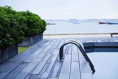 Close-up of railing by sea against sky