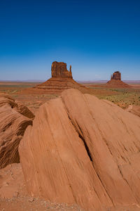 Scenic view of rock formations against clear blue sky