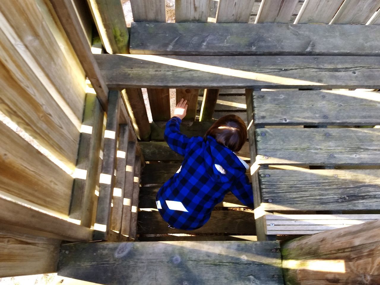 HIGH ANGLE VIEW OF MAN CLIMBING UP STAIRCASE