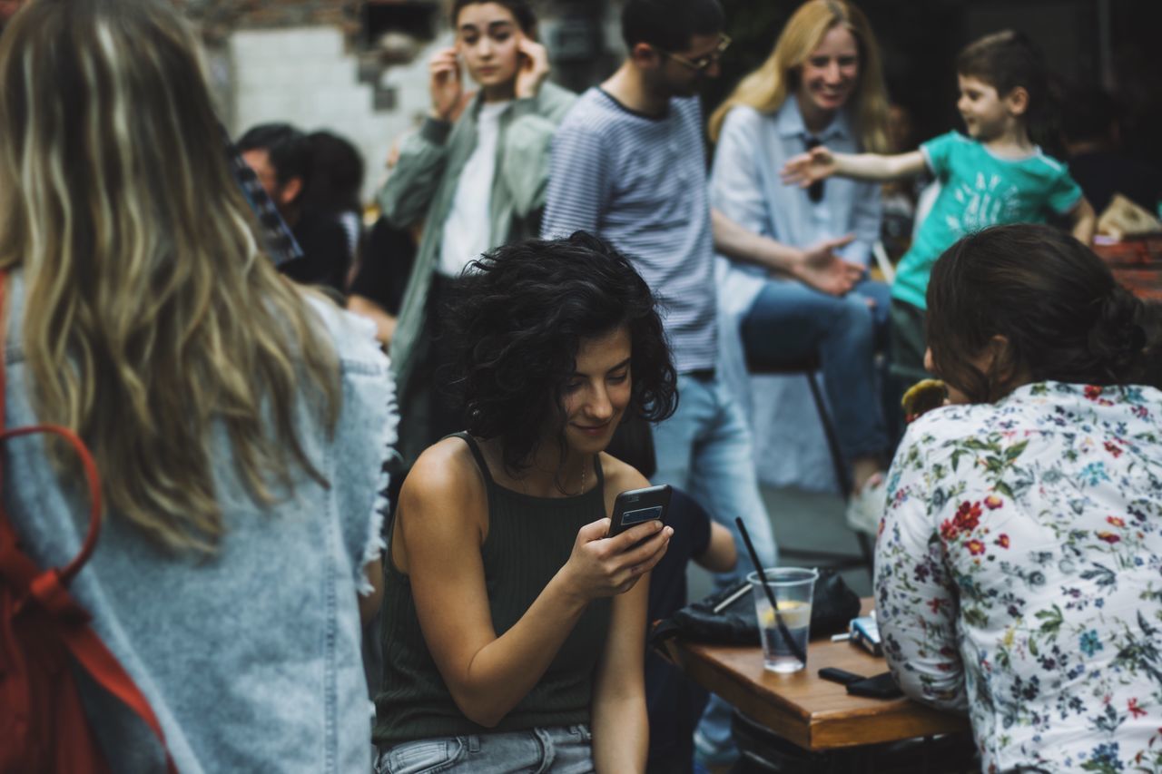 Friends sitting at outdoor cafe in city