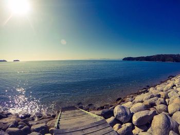 Scenic view of sea against clear sky on sunny day