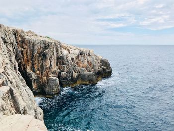 Rock formations by sea against sky