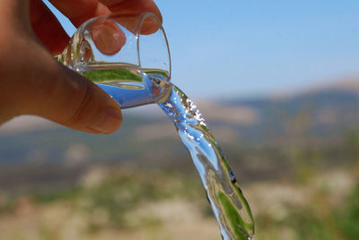 Close-up of hand holding glass of water