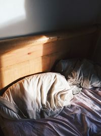 High angle view of sunlight on wooden headboard in bedroom at home