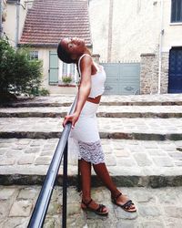 Side view of woman standing against building