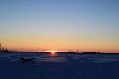 Scenic view of snow against clear sky during sunset