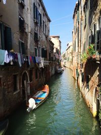 Boats in canal along buildings