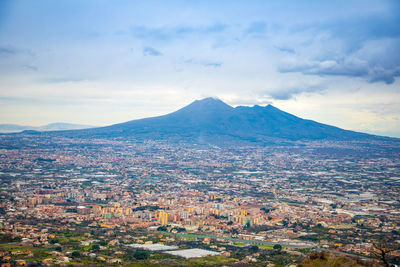 Aerial view of townscape and mountains against sky