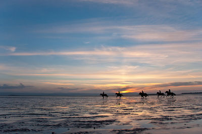 Silhouette of boat in sea during sunset