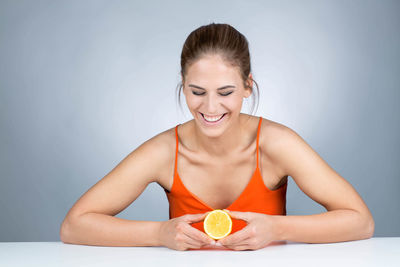 Portrait of a smiling young woman against gray background