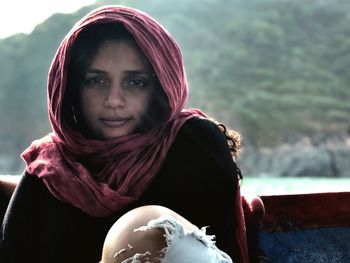 Portrait of woman wearing scarf against mountain