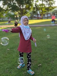 Full length of girl standing at bubbles