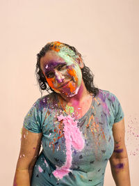 Portrait of young woman standing against white background