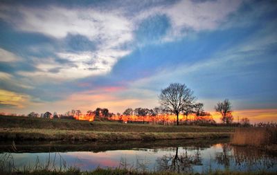 Scenic view of field against sky at sunset