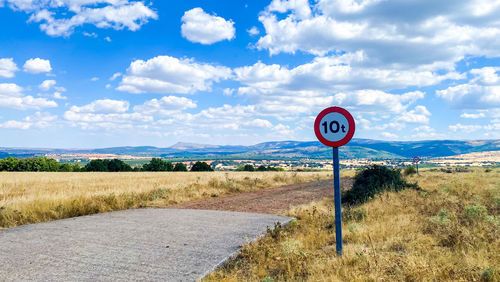 Road signs on field against sky