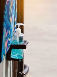 Close-up of glass bottle on table against wall