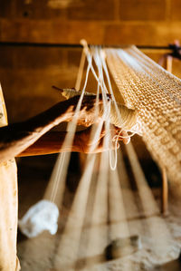 Midsection of woman waving wool in loom