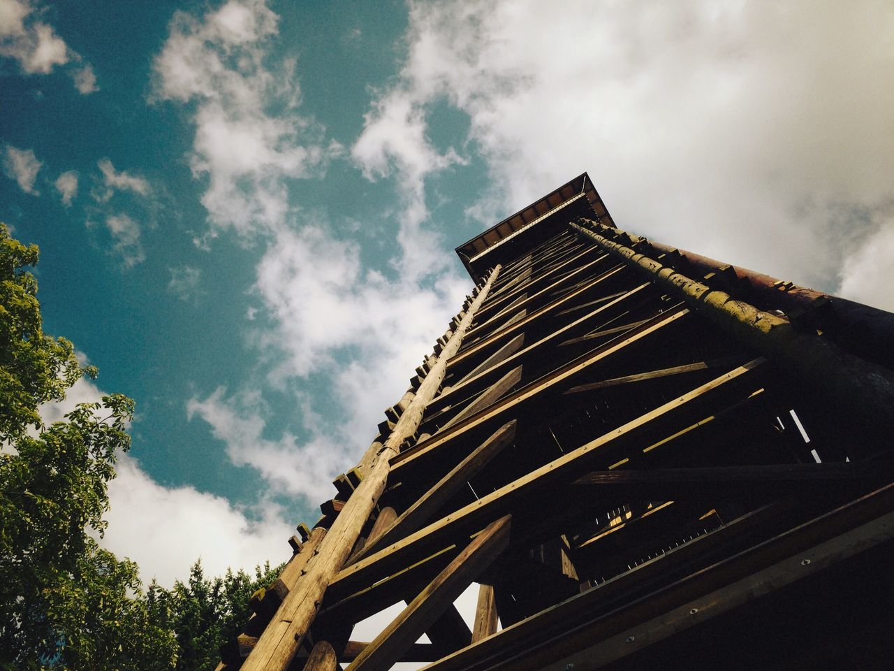 architecture, low angle view, built structure, sky, building exterior, cloud - sky, cloudy, cloud, day, outdoors, tree, history, no people, tower, architectural feature, travel destinations, tilt, city, building, sunlight