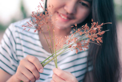 Midsection of woman holding flowering plant