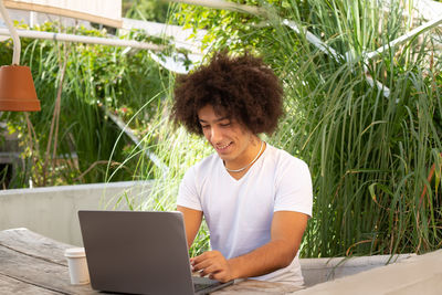 Young woman using laptop at cafe