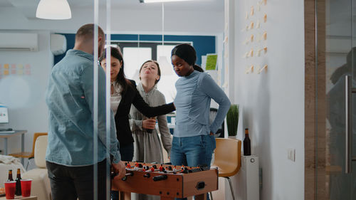 Cheerful colleagues playing foosball