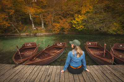 Rear view of man sitting on boat in lake