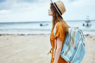 Woman wearing hat while standing on beach