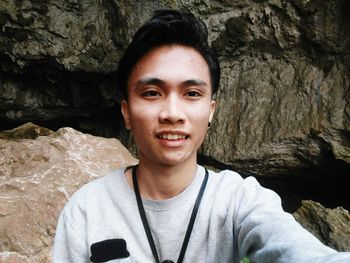 Portrait of smiling young man against rock formations