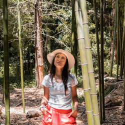 Woman wearing orange pants and summer hat walking relaxed in the forest