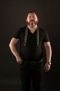 Portrait of aggressive man with metal chain against black background