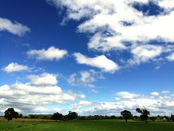 Scenic view of grassy field against cloudy sky
