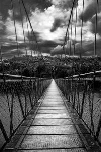 Footbridge in city against sky