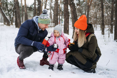 Outdoor family activities for happy winter holidays. happy father and mother playing with little