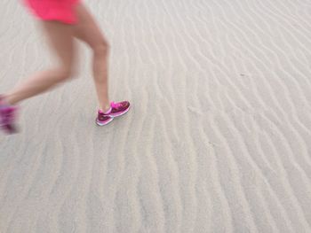 Low section of woman jogging at beach