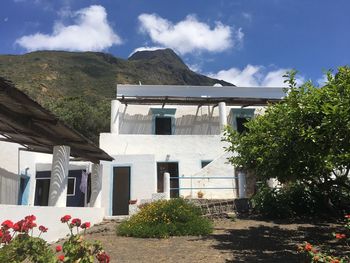 House by trees and mountains against sky