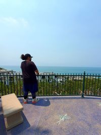 Rear view of man looking at sea against sky